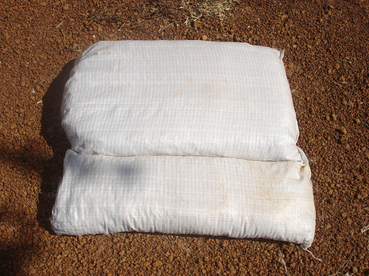 Insulation-filled tube sandbags on exterior of soil-filled earthbags creates a superinsulated wall with high thermal mass.