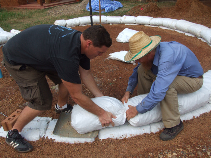 Earthbag foundation: placing gravel-filled bags