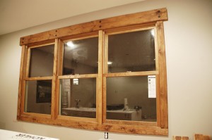 Rustic window trim with hand beveled pine boards, squared ends, honey tone stain and black lag screws