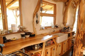 The kitchen looks out over a porch and is part of the open plan reception room of the house