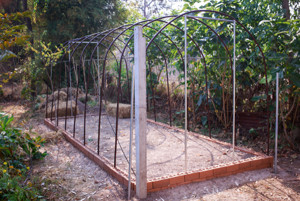 Our mesh hoop house is made with ½” rebar inside plastic tubing that fits inside a compressed earth block (CEB) foundation.