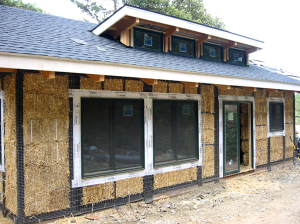 Code-approved post and beam strawbale house. Note tarpaper on wood frame.
