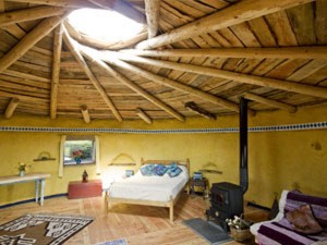 Strawbale Roundhouse -- the reciprocal frame roof and roof light express beauty and clever design